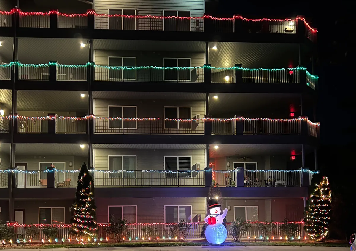 An exterior view showcasing festive decorations including decorative lights, a snowman, and a Christmas tree, creating a cheerful and welcoming holiday atmosphere outside the property.