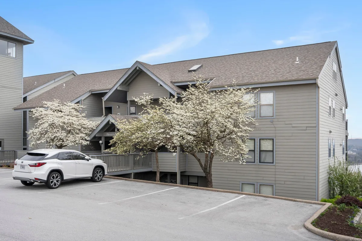 A welcoming exterior shot displaying modern architecture surrounded by blooming trees and a well-maintained parking area. The inviting landscaping hints at relaxation and easy access for families, with ample space for unloading strollers and gear.